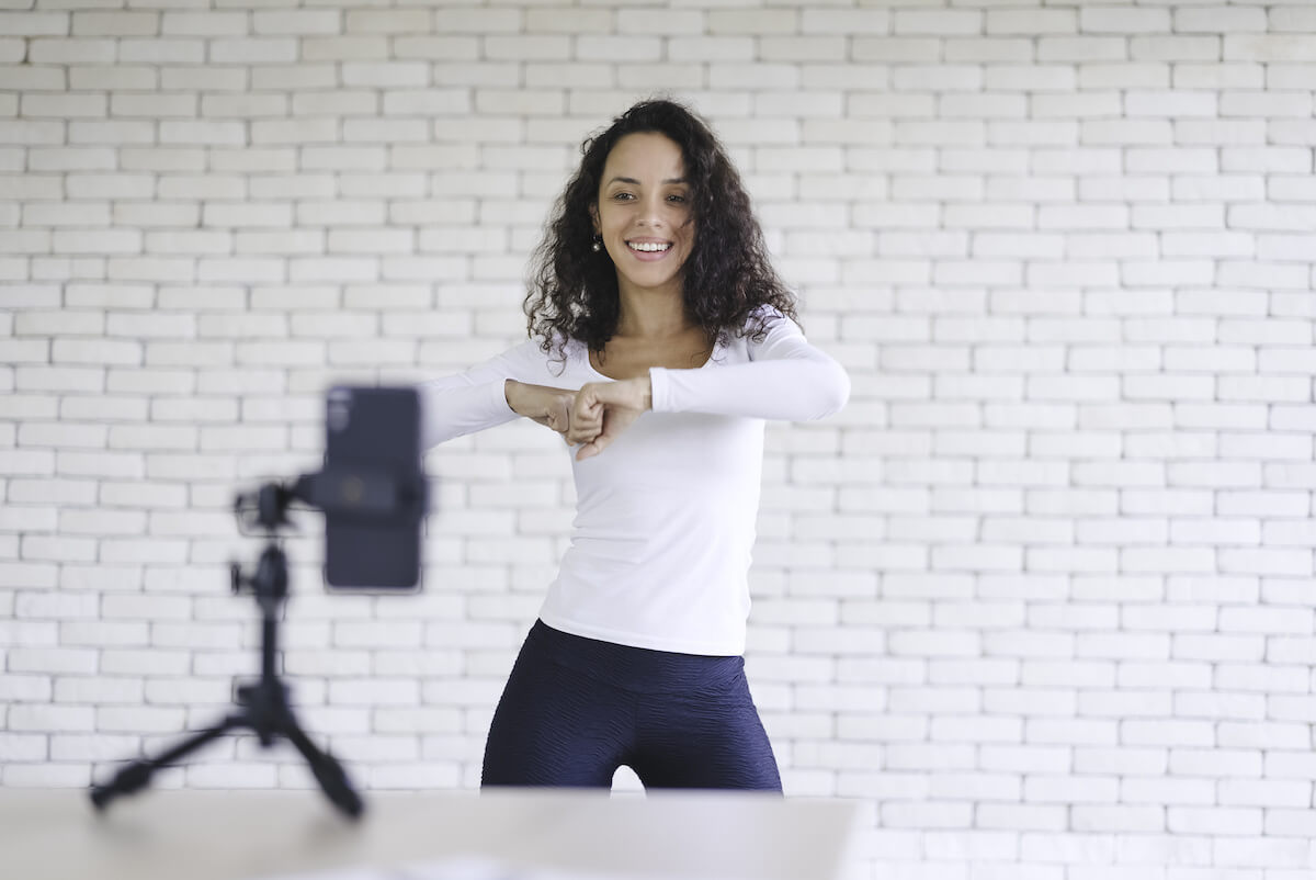 TikTok marketing strategy: woman dancing and recording a TikTok