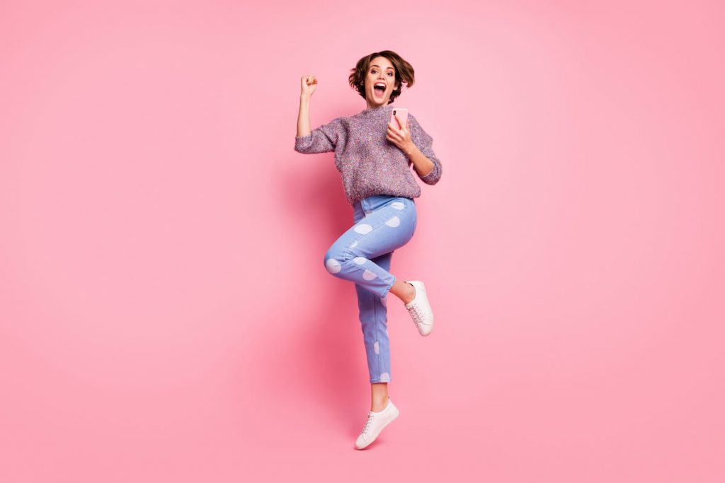 What is a brand ambassador: woman jumping while holding her phone
